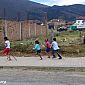 Groupe d'enfants qui jouent dans la rue, là ils font une course avec des chevaux en bois. Trop mignon !